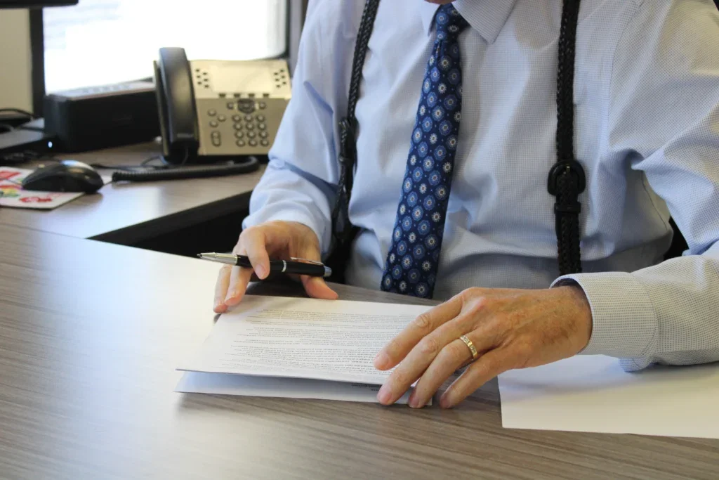 Donn Christensen Esq., reviewing a contract at a desk, his face outside of the frame.
